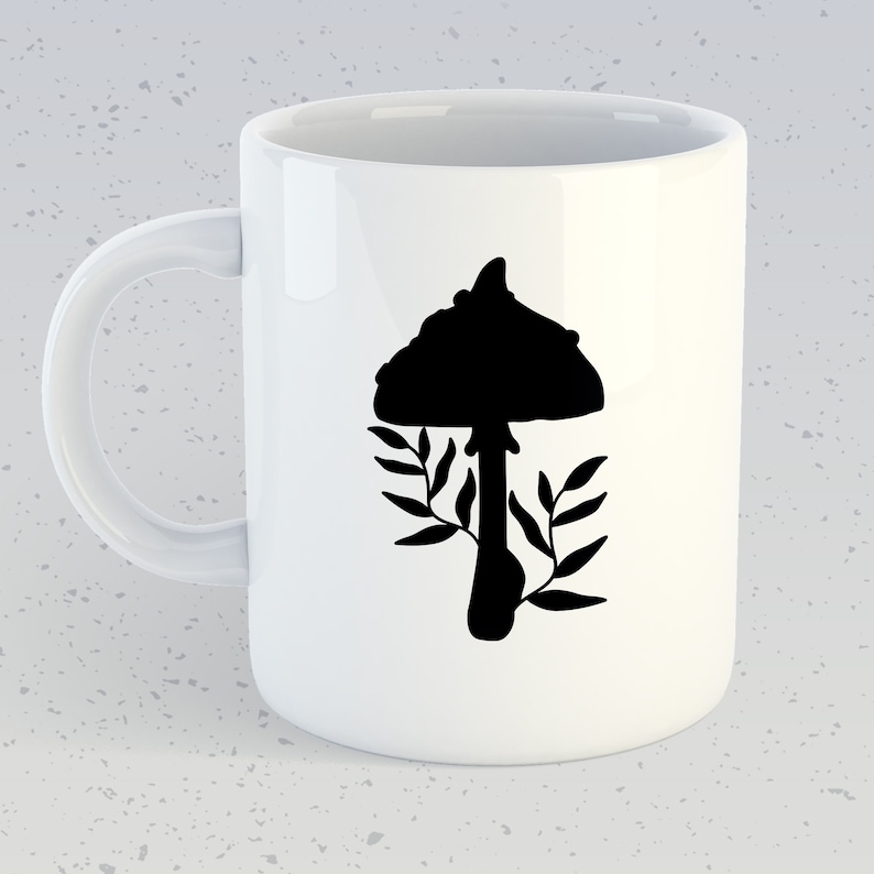 May include: White ceramic mug with a black silhouette of a mushroom and leaves. The mushroom has a rounded cap and a stem.