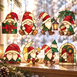 May include: A collection of eight stained glass gnome ornaments hanging in a window. The designs feature gnomes with red hats, white beards, and green clothing, holding items like a gift, heart, lantern, ornament, star, tree, and a wreath.