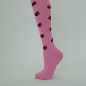 May include: Pink knee-high socks with a pattern of red ladybugs.