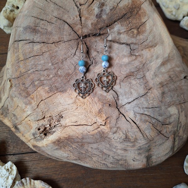 Boucles d'oreilles pendantes, pendentif argenté cœur et petite croix, perle en bois bleue, perle blanche marbrée.