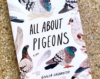 May include: A white book with the title "All About Pigeons" in black text. The cover features illustrations of pigeons in various poses, with feathers and other details. The author's name, "Giulia Casarotto", is printed in black at the bottom of the cover.