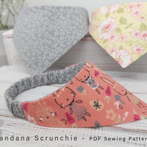 May include: Three fabric scrunchies in different patterns. The scrunchies are made from a soft, stretchy fabric and are perfect for holding hair in place. The scrunchies are in a variety of colours and patterns, including a floral pattern, a grey pattern with white dots, and a pink pattern with white bunnies.