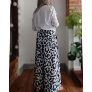 May include: A long, flowing skirt with a black and white floral print. The skirt is made of a soft, lightweight fabric and has a wrap-around style.