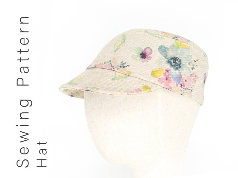 Pode incluir: Um bon&eacute; de linho bege com estampa floral em tons de rosa, azul e amarelo. O bon&eacute; tem uma aba plana e uma coroa ligeiramente curvada.