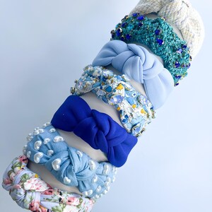 Puede incluir: Una colecci&oacute;n de diademas en varios colores y estilos. Las diademas incluyen una diadema de mezclilla azul claro con detalles de perlas blancas, una diadema con estampado floral y una diadema azul anudada. Otras diademas tienen detalles de joyas y tejidos.