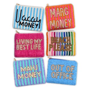 K&ouml;nnte beinhalten: Sechs Perlen-Geldb&ouml;rsen in verschiedenen Farben, jede mit einem anderen Satz. Die S&auml;tze lauten "Vacay Money", "Marg Money", "Living My Best Life", "Beach Please", "Mahj Money" und "Out of Office."