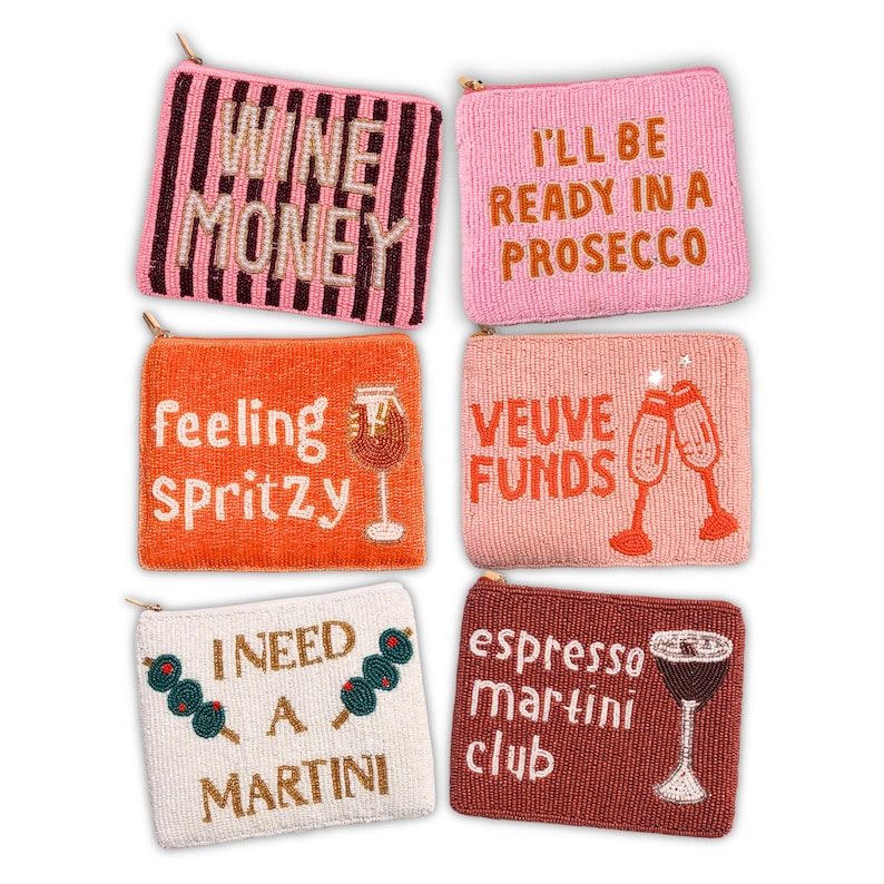 May include: Six beaded coin purses in various colors. The purses have phrases like "Wine Money", "I'll be ready in a Prosecco", "Feeling Spritzy", "Veuve Funds", "I need a Martini", and "Espresso Martini Club". Each purse has a zipper.