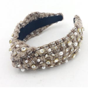 May include: A brown tweed headband with pearl and rhinestone embellishments.