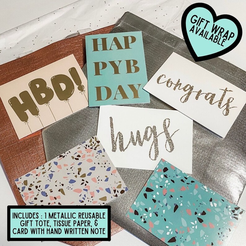 May include: A silver gift bag with a variety of greeting cards, including "HBD!" "Happy Birthday", "Congrats", "Hugs", and two patterned gift wrap sheets. The bag includes a reusable tote, tissue paper, and a card with a handwritten note. Gift wrap is available.