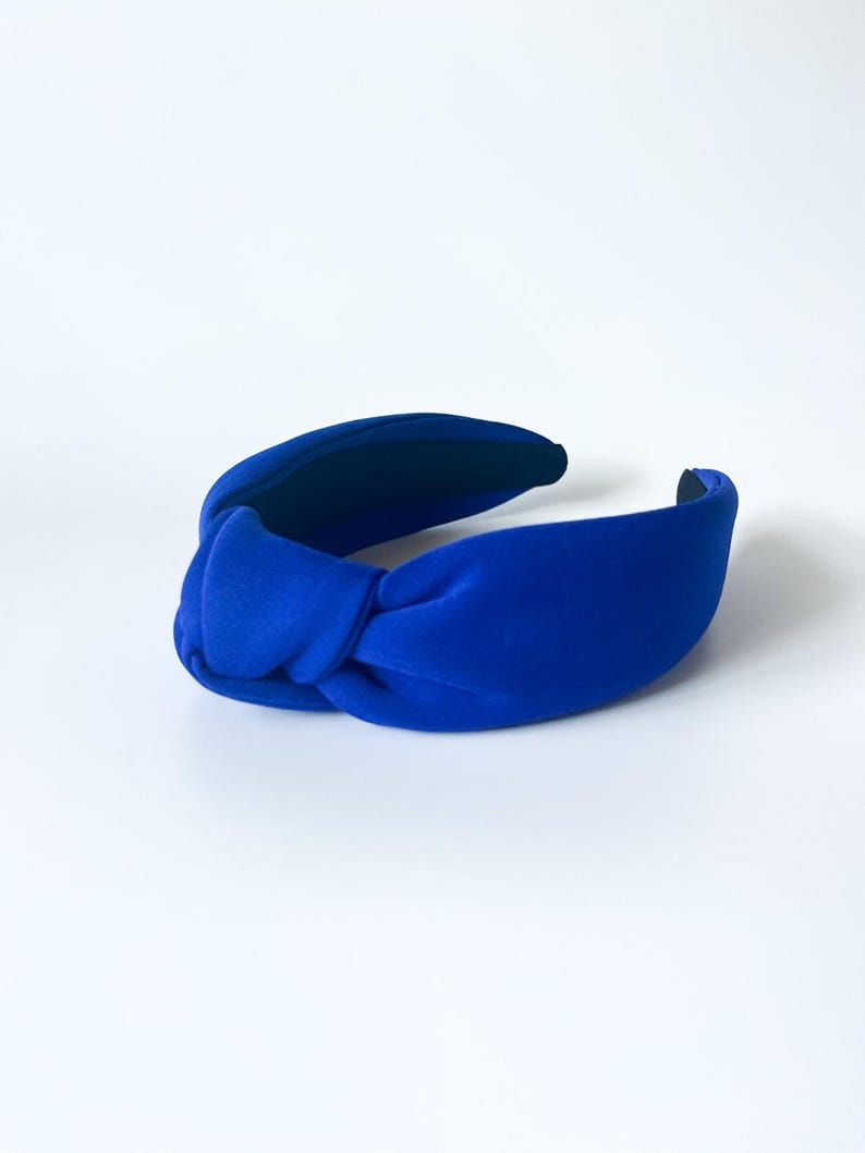 Puede incluir: Una diadema azul brillante con un dise&ntilde;o anudado. La diadema est&aacute; hecha de un material suave y aterciopelado y es de un color s&oacute;lido y llamativo. El accesorio est&aacute; dise&ntilde;ado para ser usado en la cabeza.