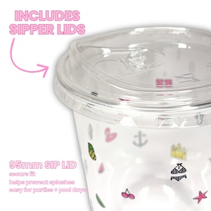 Op de afbeelding: Een doorzichtige plastic wegwerpbeker met een 95mm drinkdeksel en een patroon van kleine kleurrijke iconen waaronder ananassen, ankers, bikini's, kersen en zeesterren. De tekst INCLUDES SIPPER LIDS en 95mm SIP LID staat op de afbeelding gedrukt.