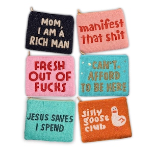 May include: Six beaded coin purses in various colors. The purses have gold zippers and feature text like "Mom, I am a rich man" and "Manifest that shit." One purse has a goose illustration.
