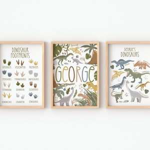 May include: Three framed prints with a dinosaur theme. The left print shows dinosaur footprints with the names of the dinosaurs below each footprint. The middle print has the name "GEORGE" in large letters with a jungle scene in the background. The right print shows various dinosaurs with their names below each dinosaur.