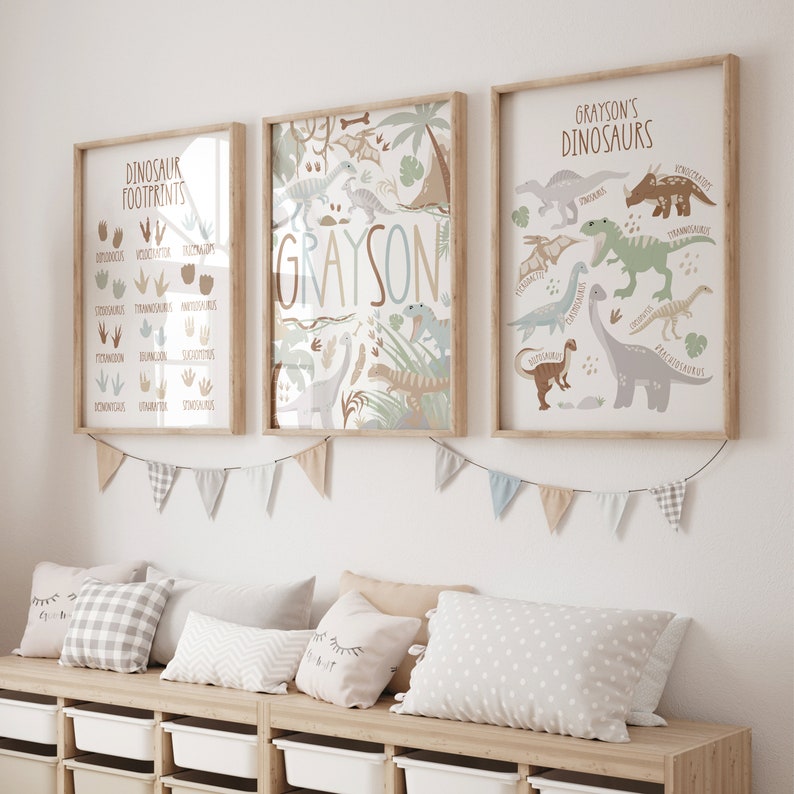 May include: Three framed prints with a dinosaur theme. The left print shows dinosaur footprints with the name of each dinosaur. The middle print has the name Grayson in large letters with a variety of dinosaurs in the background. The right print shows a variety of dinosaurs with their names listed below.