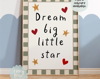 May include: Framed art print with the words "Dream big little star" in black script, accented with red hearts and gold stars. The print has a cream background and a green and white striped border. The print is from Everly Rose Prints.