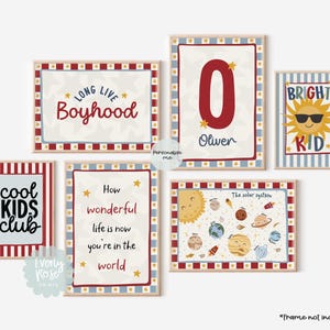 May include: A collection of framed art prints with various designs and text. The prints include phrases like "Long Live Boyhood" and "Cool Kids Club," along with a solar system illustration and a sun with sunglasses. The color scheme features red, blue, and cream.
