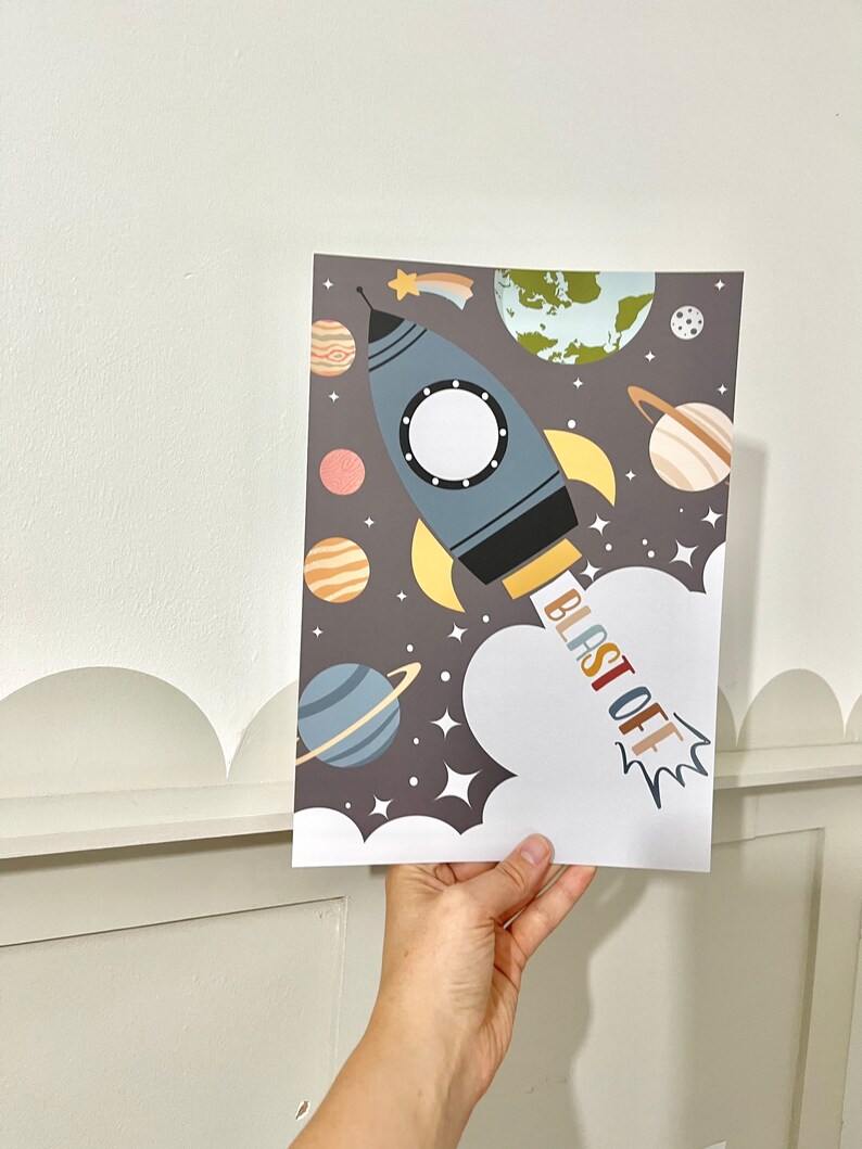 Pode incluir: Um foguete azul e amarelo com um c&iacute;rculo branco no meio, voando pelo espa&ccedil;o com planetas e estrelas. O texto "BLAST OFF" est&aacute; escrito em letras coloridas na lateral do foguete.