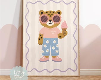 Puede incluir: Un estampado enmarcado con un leopardo de dibujos animados que lleva gafas de sol rosas, una camiseta rosa con el texto "Cool Cats Club" y vaqueros azules con estampados de margaritas. El leopardo sostiene un cono de helado rosa. El fondo tiene un patrón de rayas.
