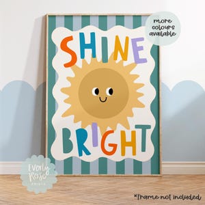 Puede incluir: Una impresi&oacute;n art&iacute;stica enmarcada con un dise&ntilde;o alegre. La obra presenta un sol sonriente y las palabras "SHINE BRIGHT" en letras coloridas. El fondo tiene un patr&oacute;n de rayas en tonos azules y blancos. Tambi&eacute;n est&aacute; presente el texto "more colours available".