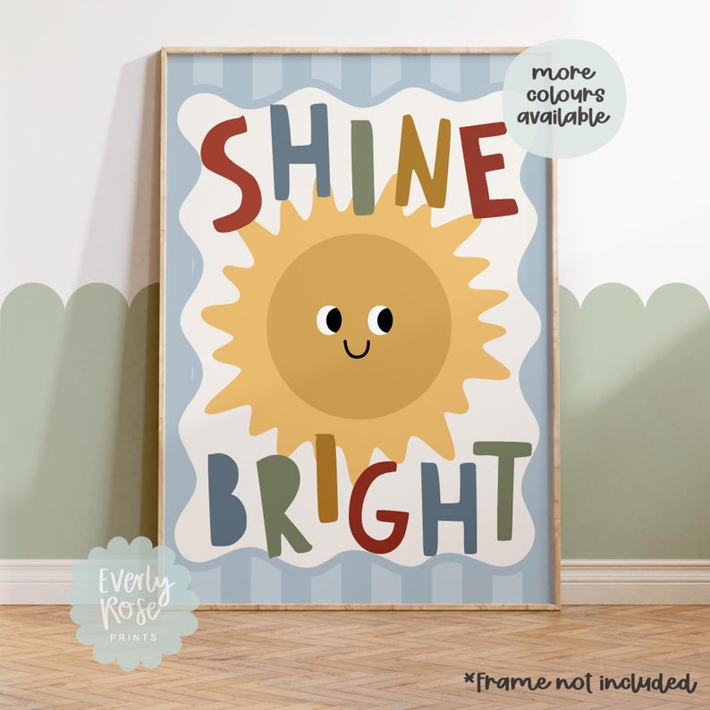 Puede incluir: Una impresi&oacute;n art&iacute;stica enmarcada con una ilustraci&oacute;n de sol alegre y las palabras "SHINE BRIGHT" en letras coloridas. La impresi&oacute;n tiene un fondo azul claro con rayas verticales y un borde blanco. Una burbuja de texto dice "more colours available".