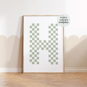 May include: A framed print of the letter H in a green and white checkered pattern. The frame is not included.