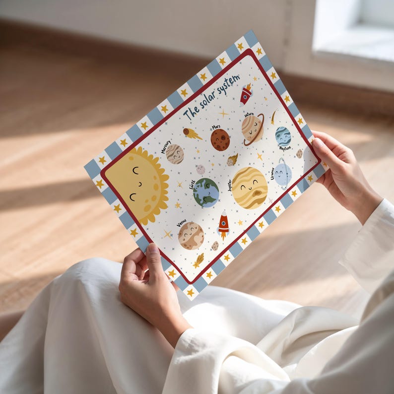 May include: A colorful educational poster titled "The solar system" featuring illustrations of planets, the sun, and rockets. The poster has a blue and white striped border with gold stars. The planets have smiling faces.