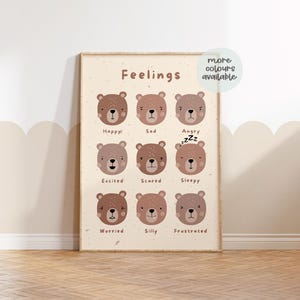 May include: A beige poster with the word "Feelings" at the top. Nine brown bear faces with different expressions are shown, each labeled with a feeling word: Happy, Sad, Angry, Excited, Scared, Sleepy, Worried, Silly, and Frustrated. The text "more colours available" is in a circle at the top right corner.
