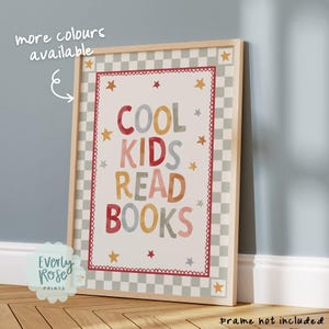 May include: A rectangular wall art print featuring the text COOL KIDS READ BOOKS in multi-colored letters. The design includes a red scalloped border, scattered yellow and red stars, and a grey and white checkered frame pattern on a light background.