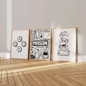 May include: Three framed black and white illustrations of video game controllers and other gaming imagery. The centre illustration features the text "MASON IS ONLINE".