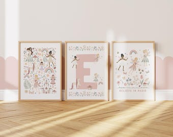 May include: Three pink and white framed prints with illustrations of fairies and flowers. The center print features a large pink letter E. The print on the right says "Believe in Magic".