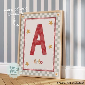 May include: A rectangular wall print featuring a large red letter A with a star pattern, centred above the name Arlo in multicoloured text. The design includes yellow stars, a red scalloped border, and a grey and white checkered frame.