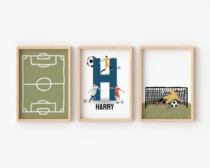 May include: Three framed prints with a soccer theme. The first print shows a green soccer field with white lines. The second print shows the letter H in blue with soccer players in yellow and white uniforms. The third print shows a soccer player in a yellow uniform diving to save a goal. The text "HARRY" is below the letter H.