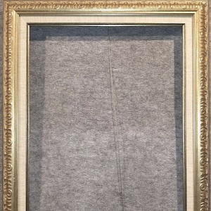 May include: A gold-colored picture frame with a white mat and a decorative ornate border. The frame is empty.