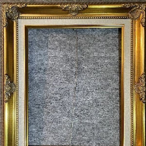 Könnte beinhalten: Ein goldfarbener Bilderrahmen mit verzierten Details. Der Rahmen hat einen weißen Passepartout und eine graue Rückseite.
