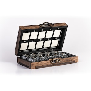 May include: A wooden box with a hinged lid and a brass latch. The box is divided into ten compartments, each numbered 1 through 10. The box is filled with small glass vials.