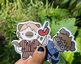 May include: Two die-cut stickers featuring cartoon animal characters. One is a cat in a brown pinstripe suit holding a knife and a heart. The other is a dog in a blue plaid shirt and glasses, also holding a knife.