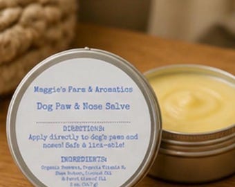 Könnte beinhalten: Eine kleine, offene Dose mit gelber Pfoten- und Nasensalbe für Hunde neben einer geschlossenen Dose mit einem Etikett. Auf dem Etikett steht "Maggie's Fara & Aromatics Dog Paw & Nose Salve". Die Salbe ist sicher und zum Ablecken geeignet. Die Inhaltsstoffe sind Bio-Bienenwachs und Vitamin E.