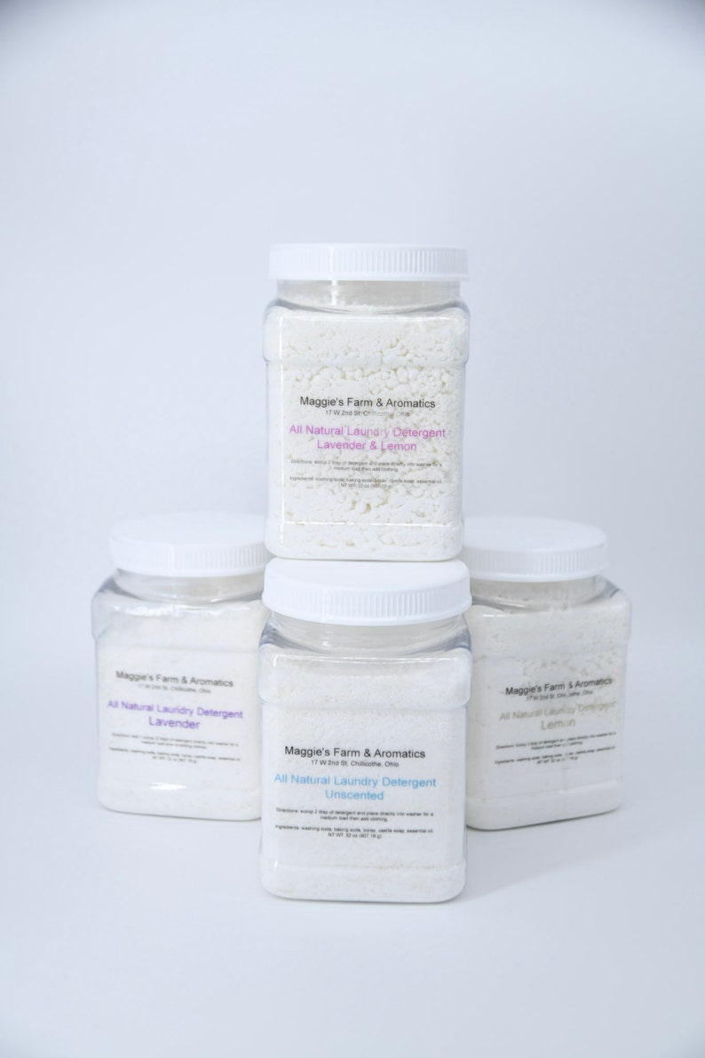 Puede incluir: Cuatro frascos de pl&aacute;stico transparente de detergente para ropa con tapas blancas est&aacute;n apilados. Los frascos contienen polvo blanco y tienen etiquetas que dicen "Maggie's Farm & Aromatics" y "All Natural Laundry Detergent". Los aromas son Lavanda, Lim&oacute;n y Sin perfume.