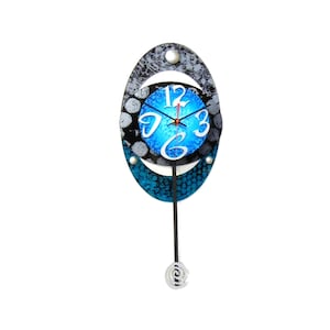 May include: A blue and black oval pendulum clock with a white face and black numbers. The clock has a silver pendulum and a silver ring at the bottom.