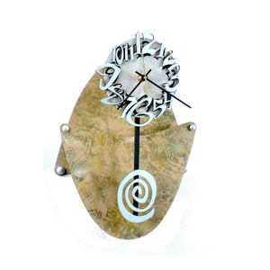 May include: A unique wall clock with a gold and brown textured background. The clock face features silver numbers and hands, and the pendulum is a silver spiral.