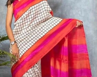 May include: A white saree with a black checkered pattern and a red, orange, and pink border. The saree is draped around a person's body.