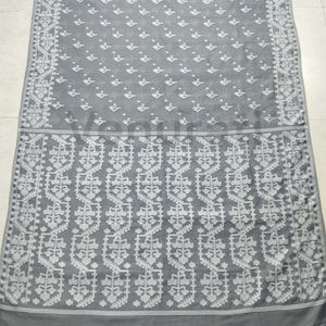 May include: A gray and white cotton saree with a floral pattern. The saree has a white border with a geometric design.