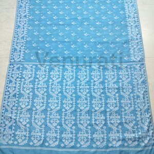 May include: A light blue saree with a white floral pattern. The saree has a border with a repeating geometric design.