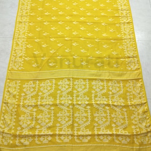 May include: A yellow cotton saree with a white floral pattern. The saree has a border with a white floral design.