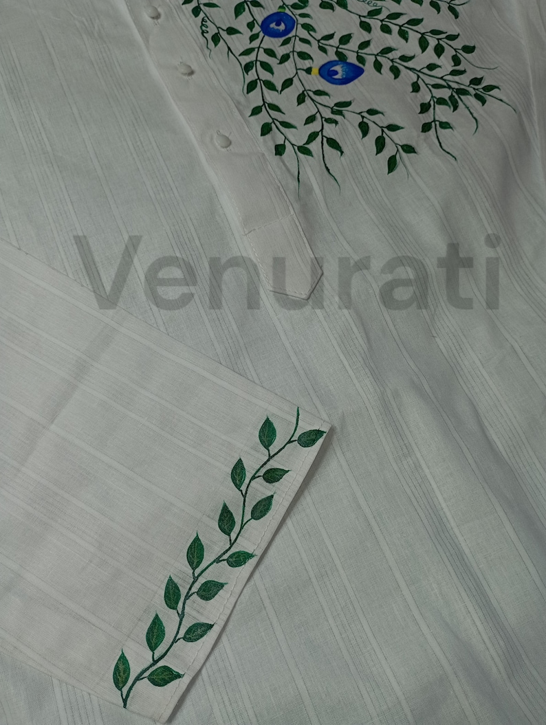 May include: White shirt with green leaf designs painted on the collar and cuff. The shirt has a striped pattern.