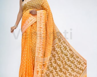 May include: A yellow and gold saree with a white polka dot pattern and floral design. The saree has a thin gold border and a contrasting gold and white design on the pallu.