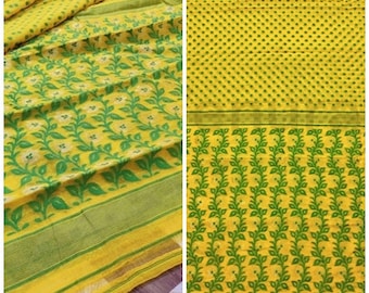 May include: Yellow and green patterned fabric with a floral design. The fabric has a repeating pattern of green leaves and yellow flowers.