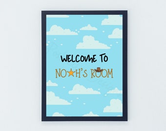 May include: A blue and white framed print with a blue background and white clouds. The print says "Welcome to Noah's Room" with a yellow star and a brown cowboy hat.