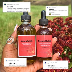 K&ouml;nnte beinhalten: Zwei Glasflaschen mit Naturally Cali Super Concentrated Hair Growth Oil werden in einer Hand gehalten. Jede Flasche hat ein rotes Etikett mit wei&szlig;em Text und einem floralen Design. Die Flaschen sind mit einer goldfarbenen Fl&uuml;ssigkeit gef&uuml;llt. Der Hintergrund zeigt rote Blumen.