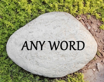 Può includere: Un grande sasso rotondo grigio con le parole "ANY WORD" incise in lettere nere.